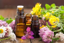 essential oil bottles with flowers on a wood bed